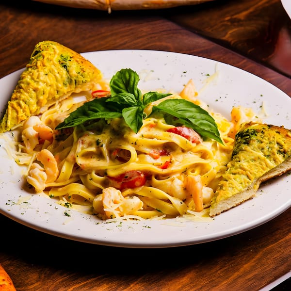 Creamy shrimp fettuccine with tomatoes, basil, and two slices of cheesy garlic bread.